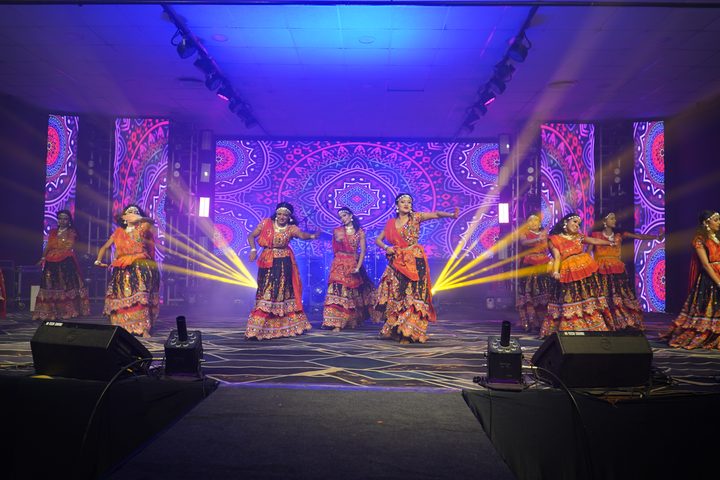 Dancers in colourful lehengas performing a garba-style routine