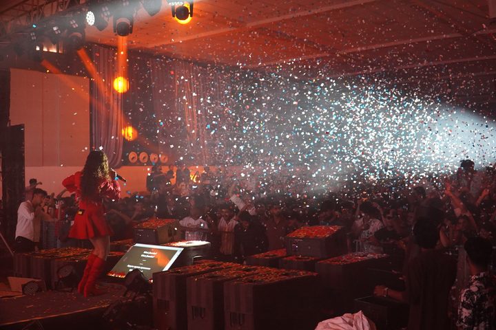 Singer performing on stage as confetti rains over the crowd